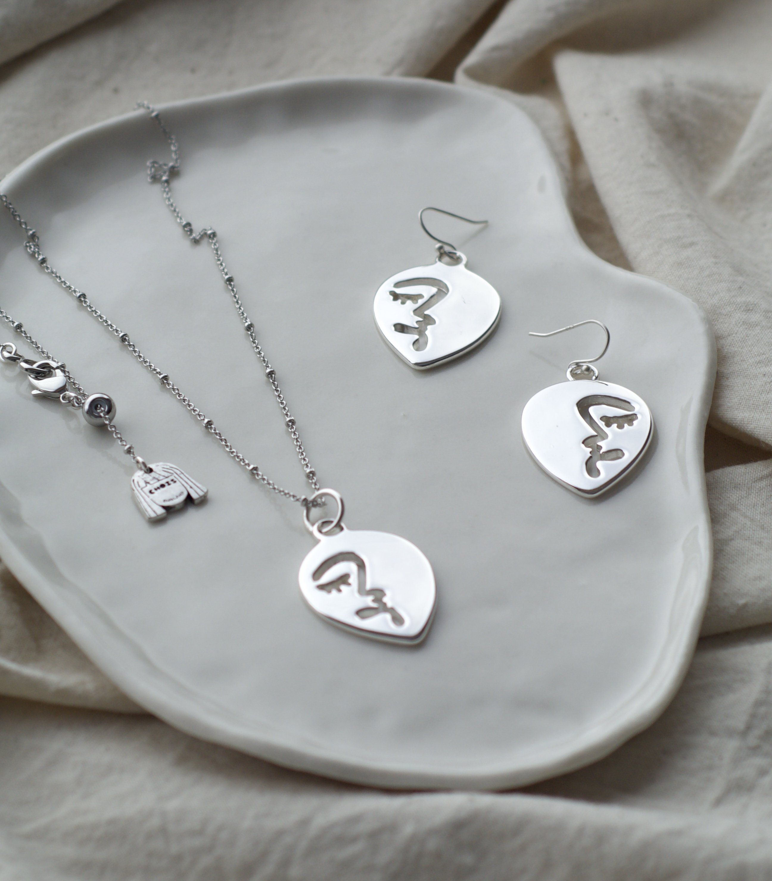 Abstract Face Pendant Necklace & Earring Set In White Gold Tone