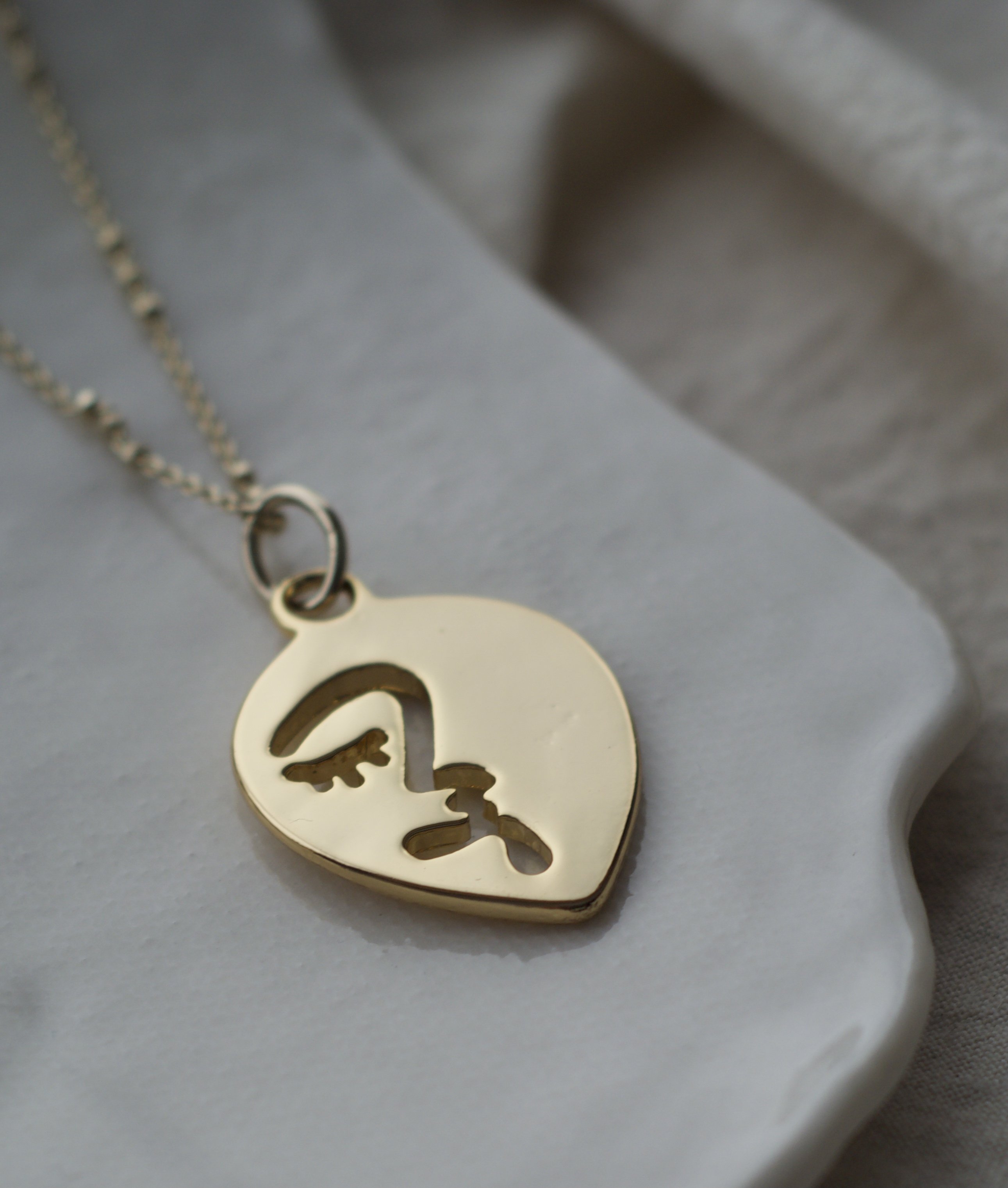 Abstract Face Pendant In Gold Tone