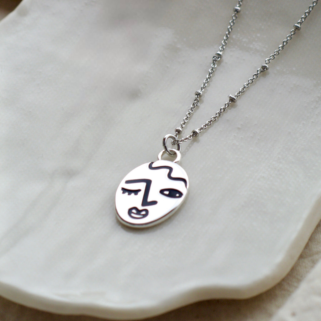 Winking lady face necklace