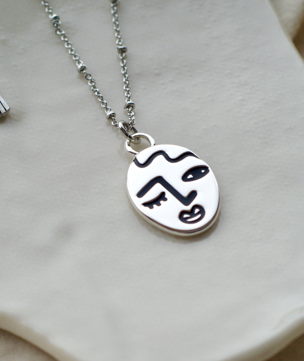 Winking lady face necklace