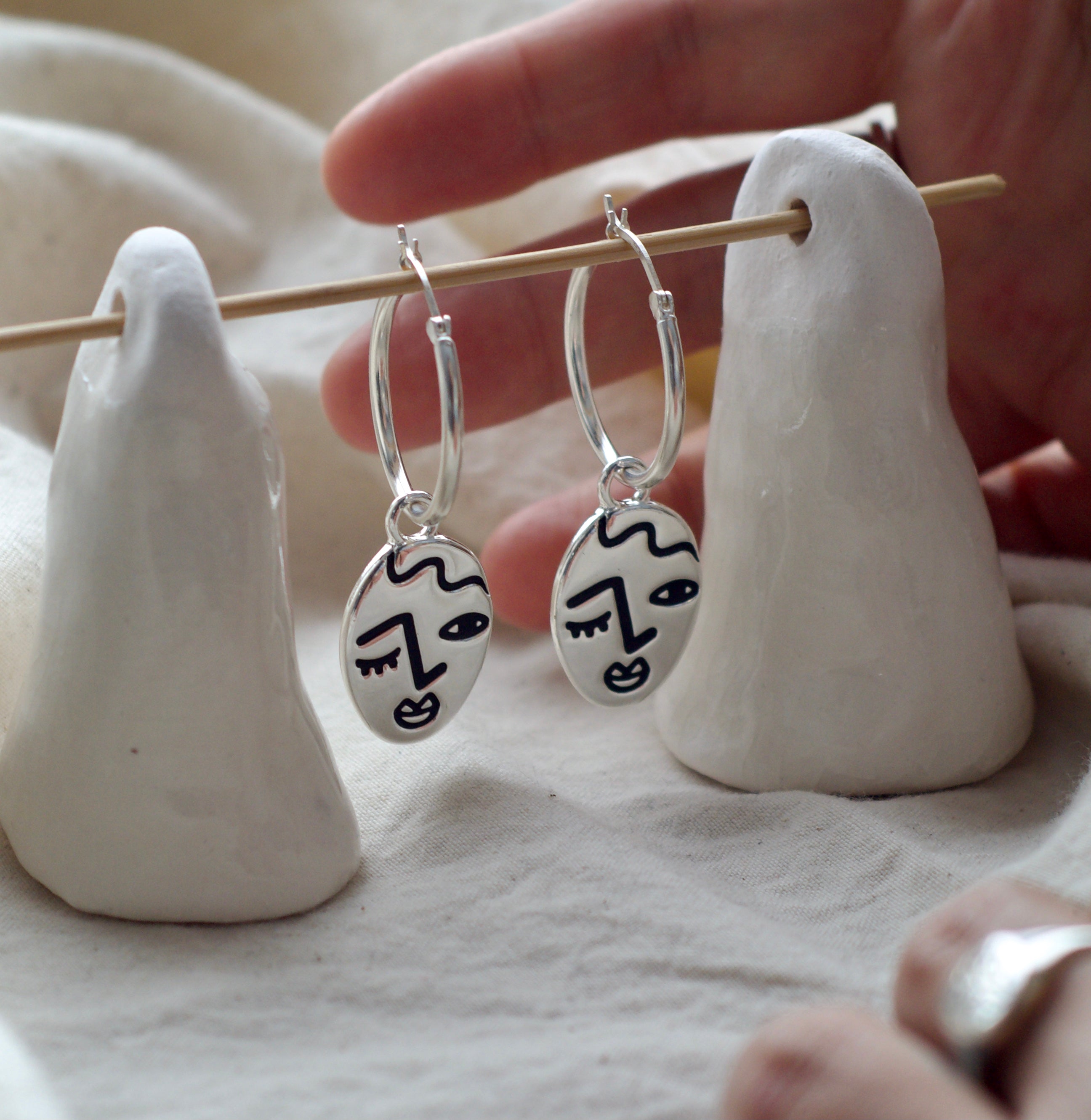 Winking lady face hoop earrings