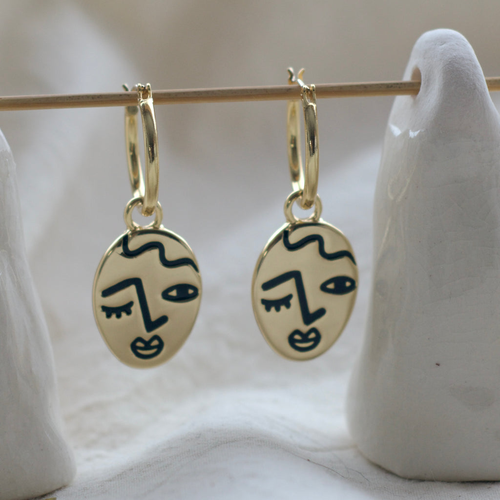 Winking lady face hoop earrings