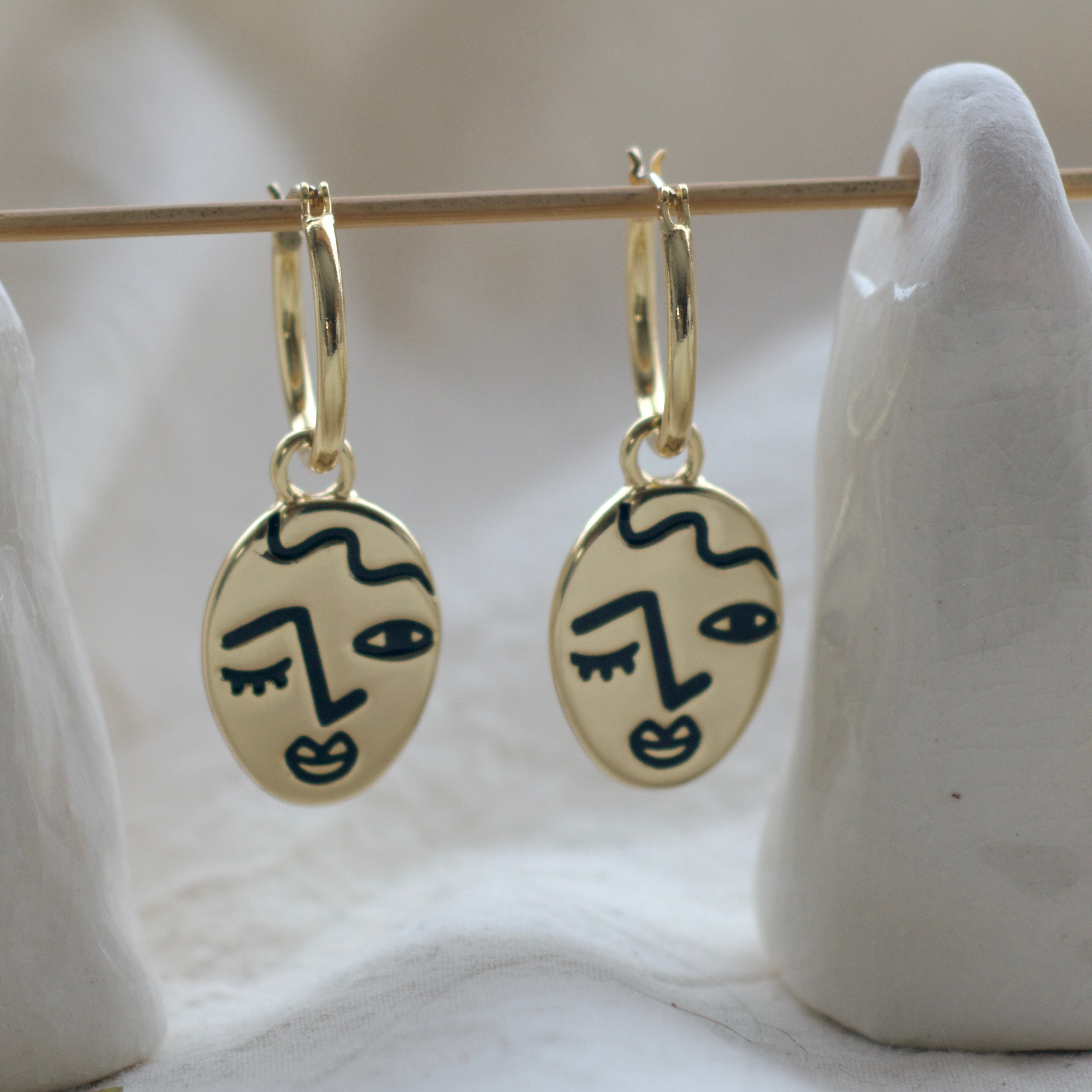 Winking lady face hoop earrings