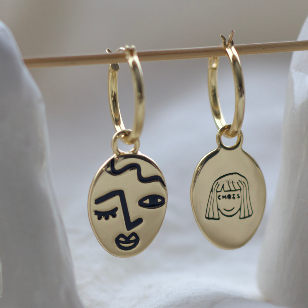 Winking lady face hoop earrings