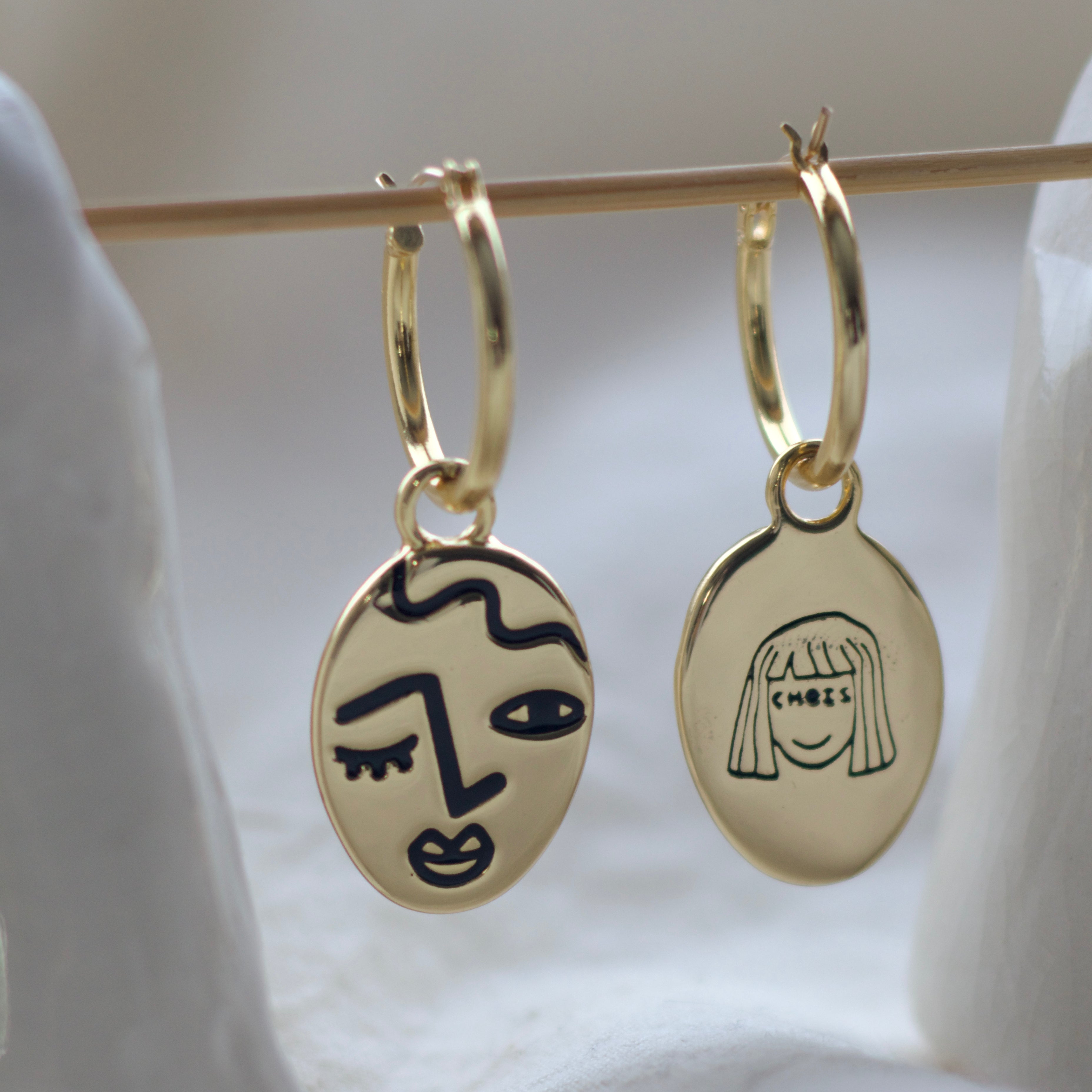 Winking lady face hoop earrings