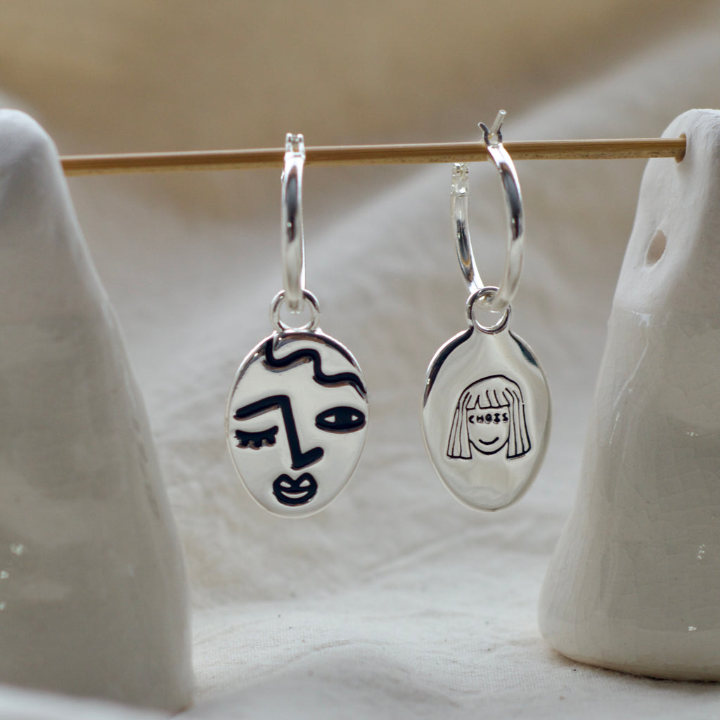 Winking lady face hoop earrings