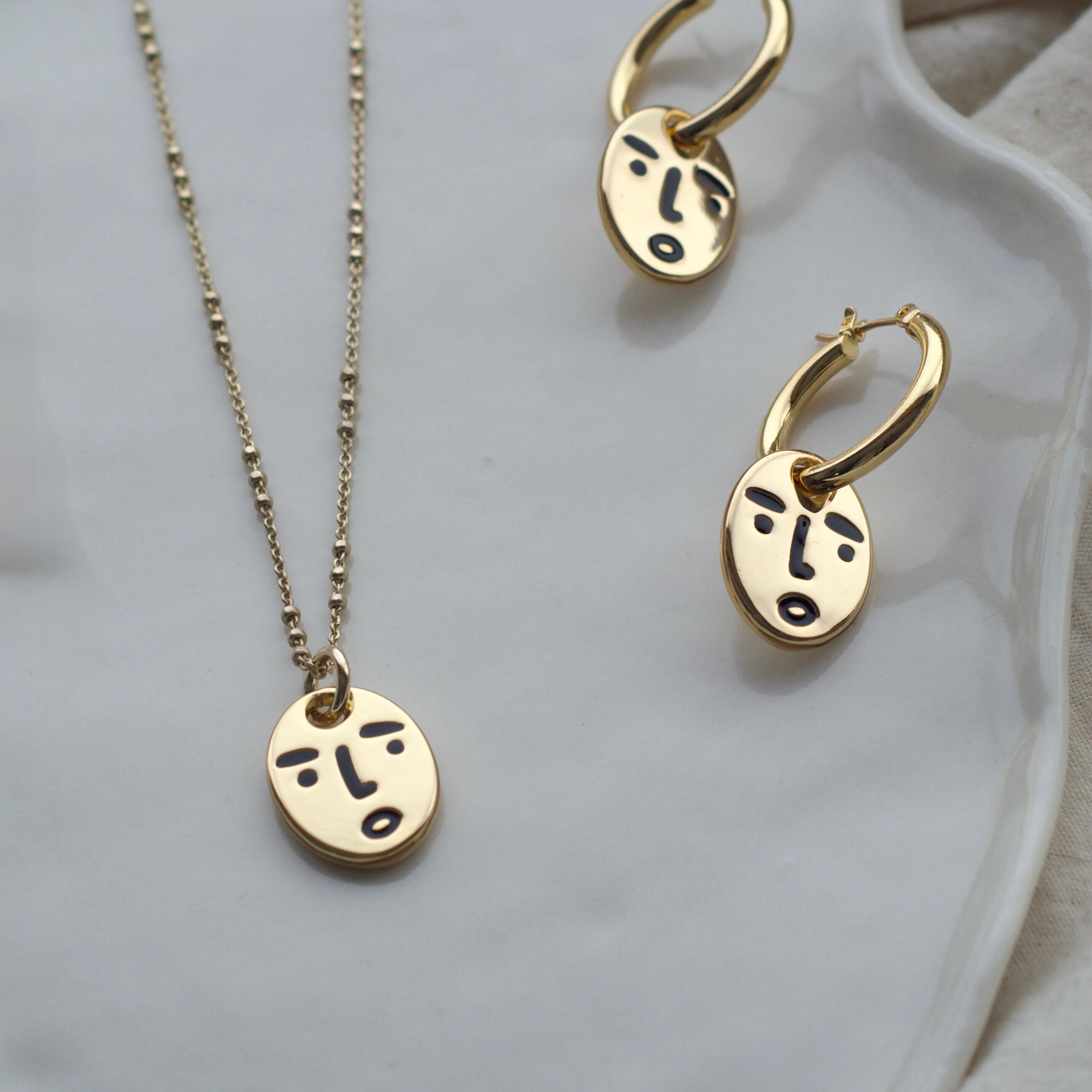 Clueless face hoop earrings