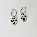 Winking lady face hoop earrings