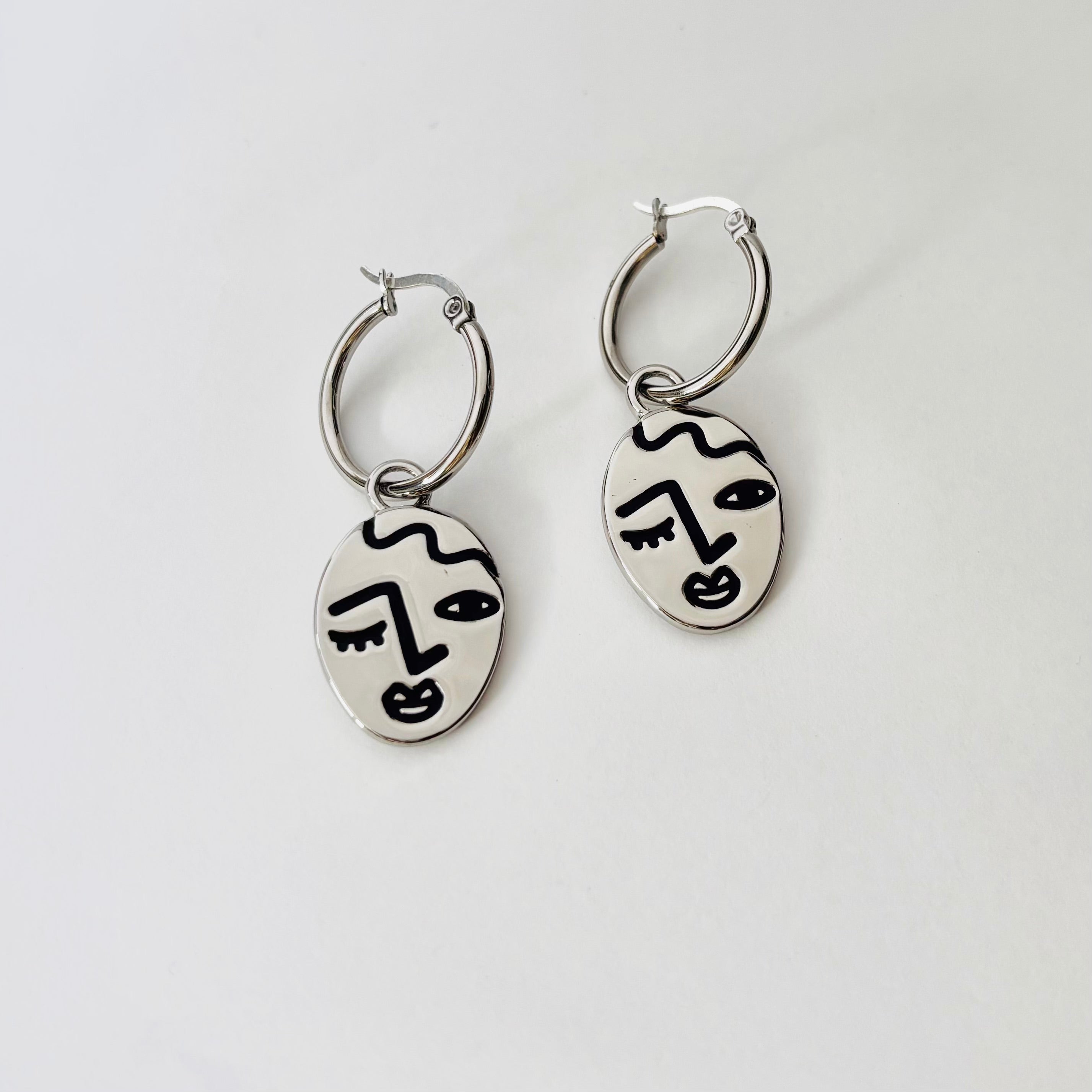 Winking lady face hoop earrings