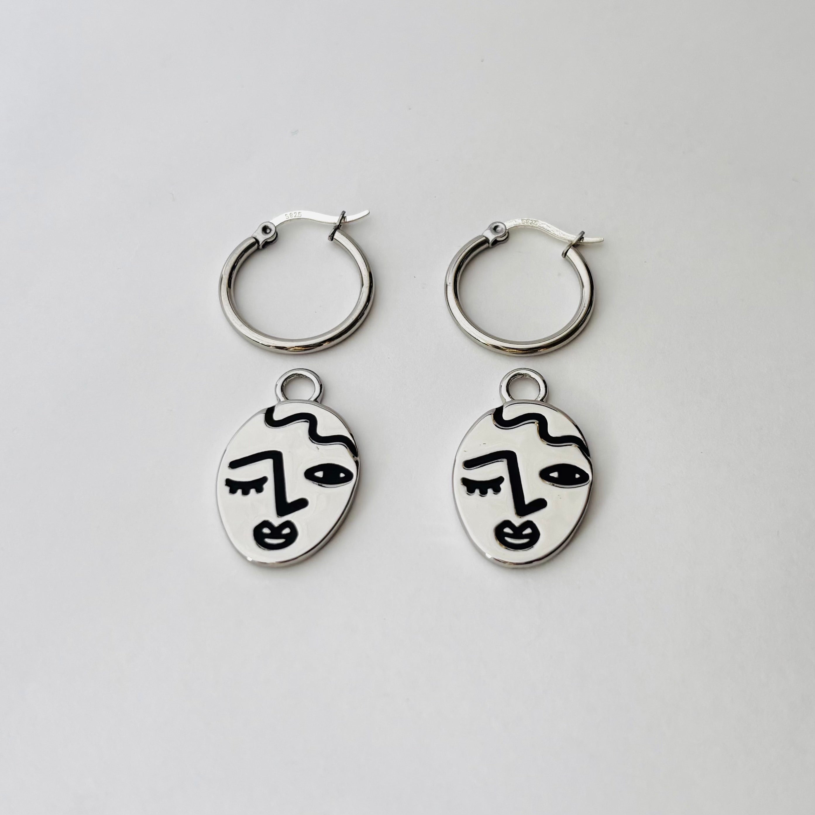 Winking lady face hoop earrings